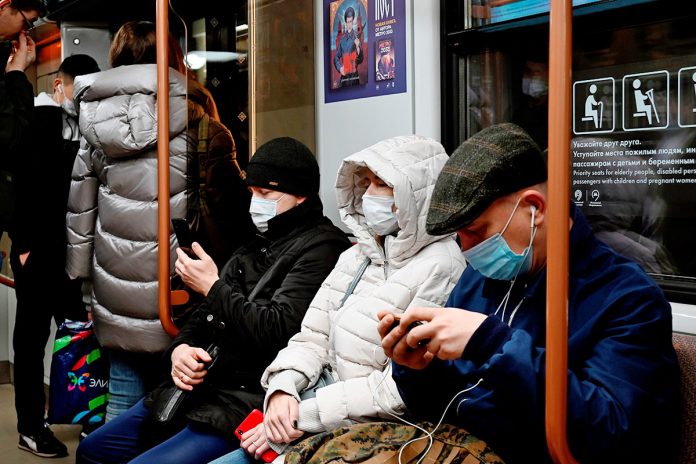 varios pasajeros usan mascarilla en el metro de Moscú en Rusia